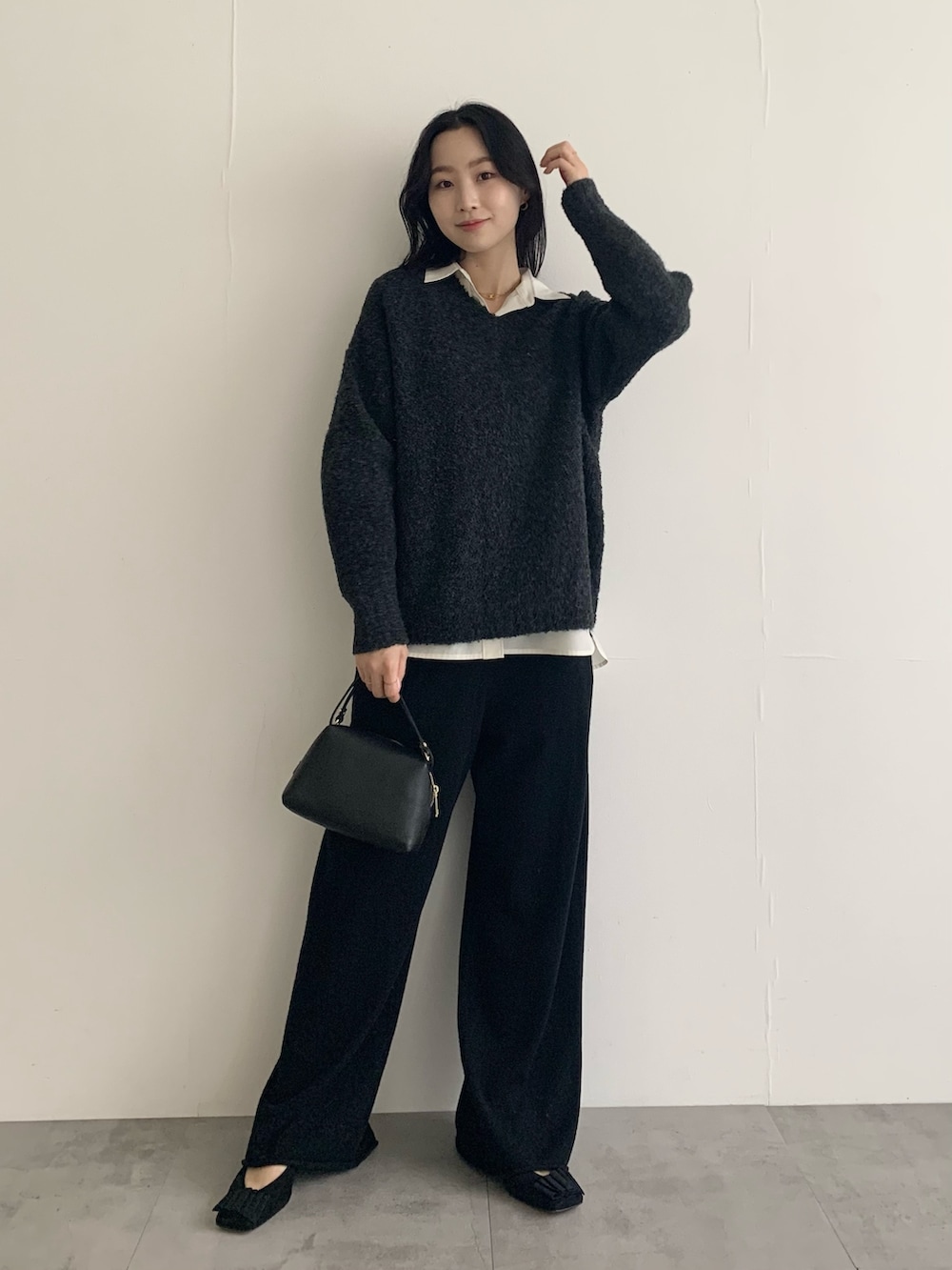 グレー系のニット/セーター、ホワイト系のシャツ/ブラウス、ブラック系のその他パンツを着用したレディースの秋コーディネートの3枚目の写真
