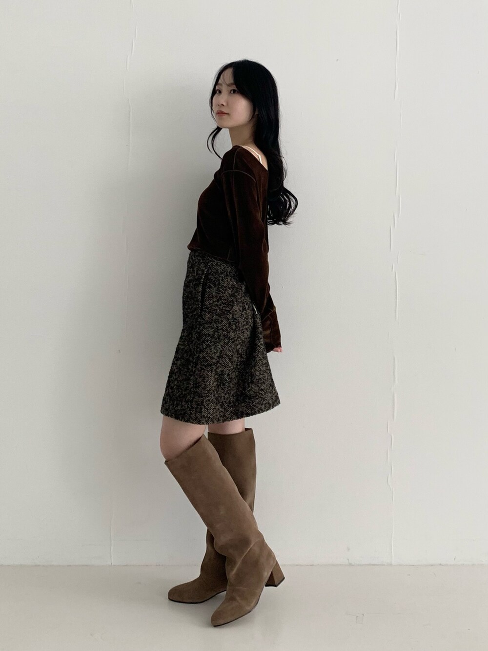 ブラウン系のTシャツ/カットソー、ベージュ系のスカート、ブラウン系のブーツを着用したレディースの秋コーディネートの3枚目の写真