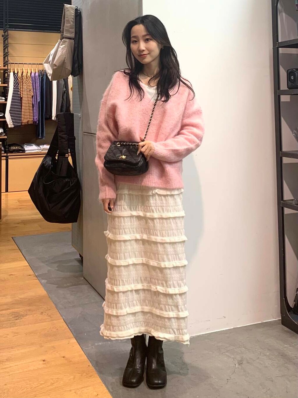 ブラック系のショルダーバッグ、ブラック系のブーツ、ピンク系のニット/セーターを着用したレディースの冬コーディネートの4枚目の写真