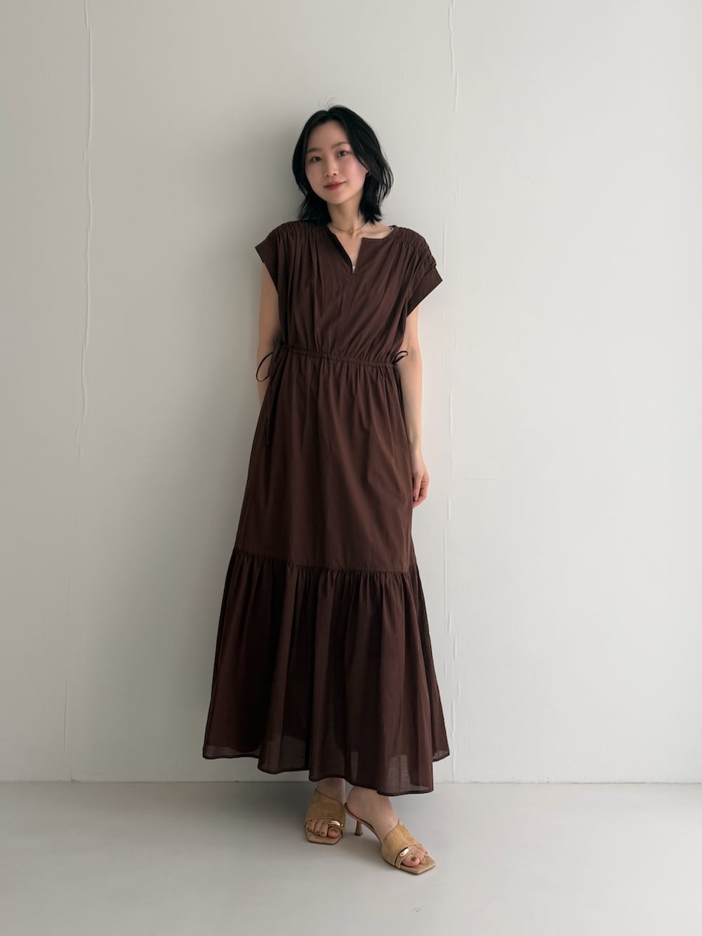 ブラウン系のワンピースを着用したレディースの春コーディネートの2枚目の写真