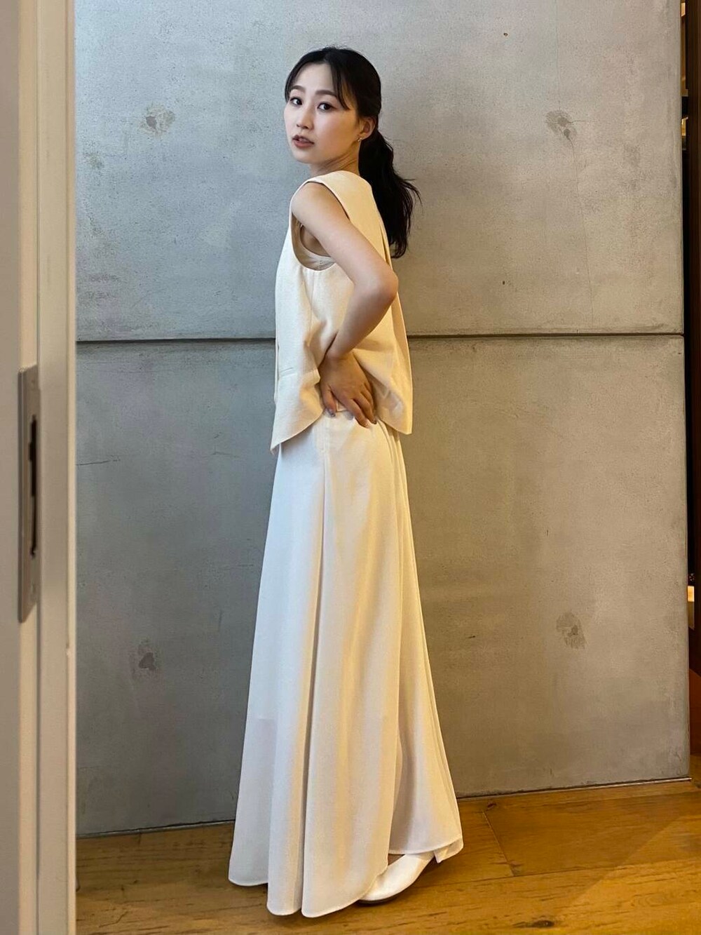 ホワイト系のパンプス、ホワイト系のベスト、ホワイト系のスカートを着用したレディースの夏コーディネートの4枚目の写真