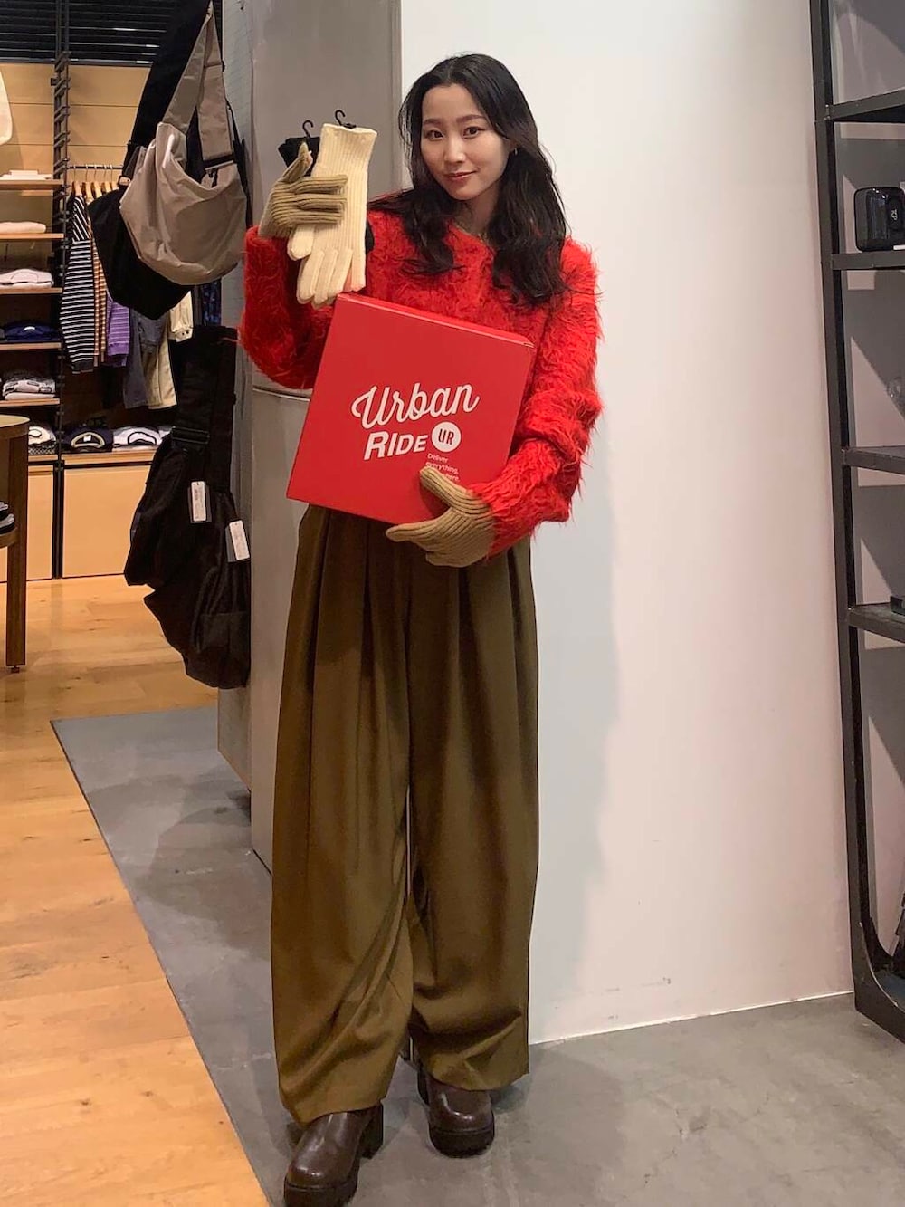 ベージュ系のその他パンツ、レッド系のカーディガン/ボレロ、ホワイト系の手袋を着用したレディースの冬コーディネートの2枚目の写真