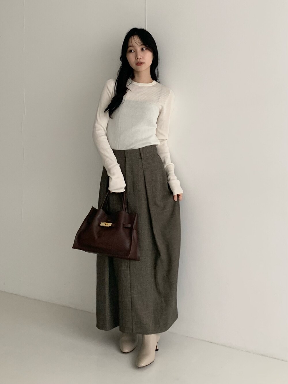 ホワイト系のニット/セーター、ブラウン系のスカートを着用したレディースの秋コーディネートの2枚目の写真