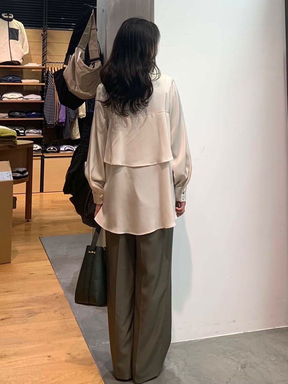 グリーン系のハンドバッグ、ブラック系のブーツ、ホワイト系のシャツ/ブラウスを着用したレディースの冬コーディネートの6枚目の写真