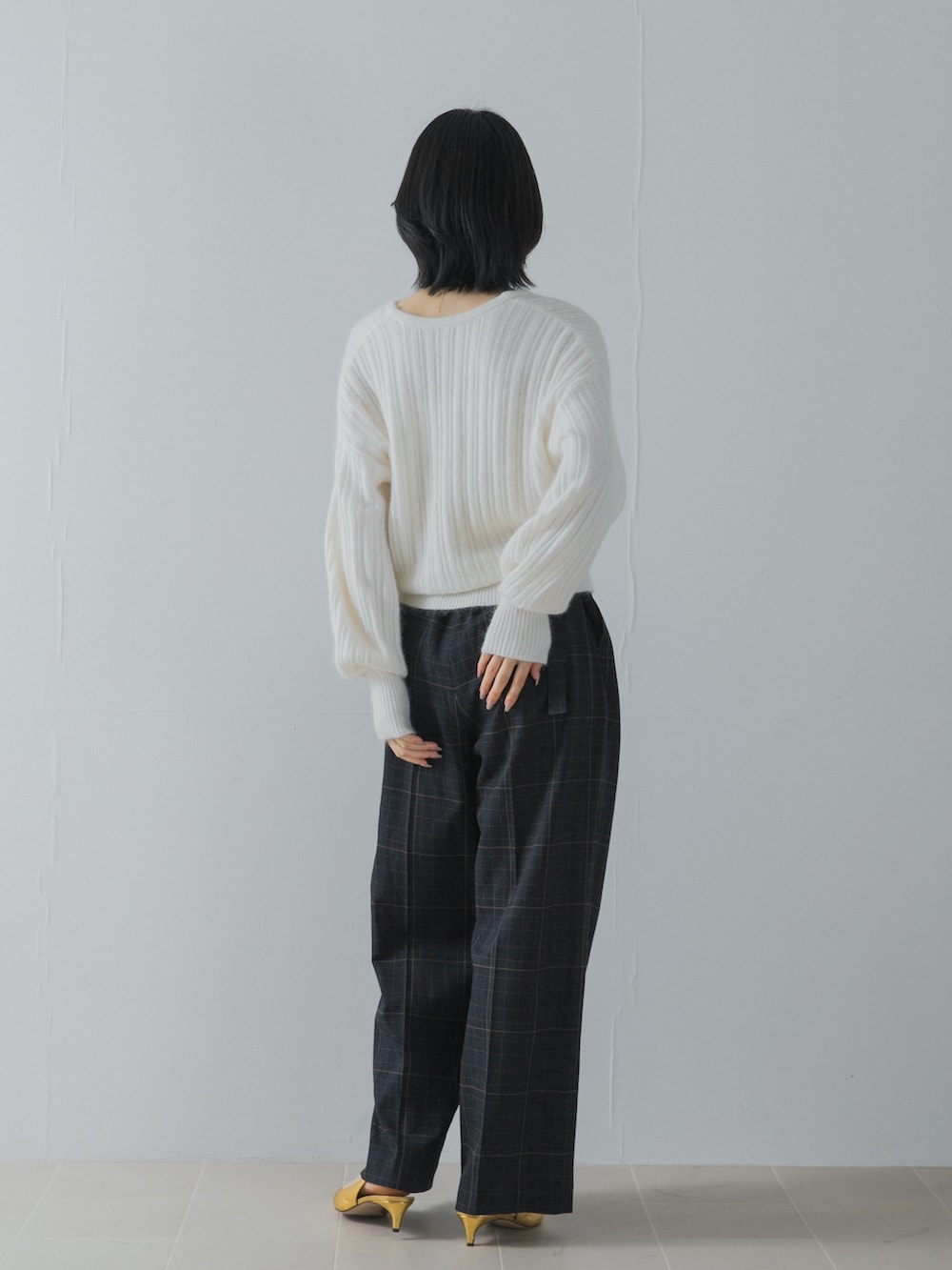 ホワイト系のニット/セーター、ブルー系のその他パンツ、ゴールド系のパンプスを着用したレディースの夏コーディネートの5枚目の写真