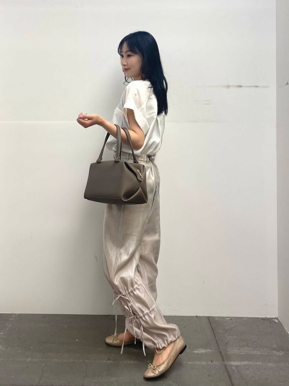 ベージュ系のハンドバッグ、ホワイト系のTシャツ/カットソー、ベージュ系のその他パンツを着用したレディースの夏コーディネートの4枚目の写真
