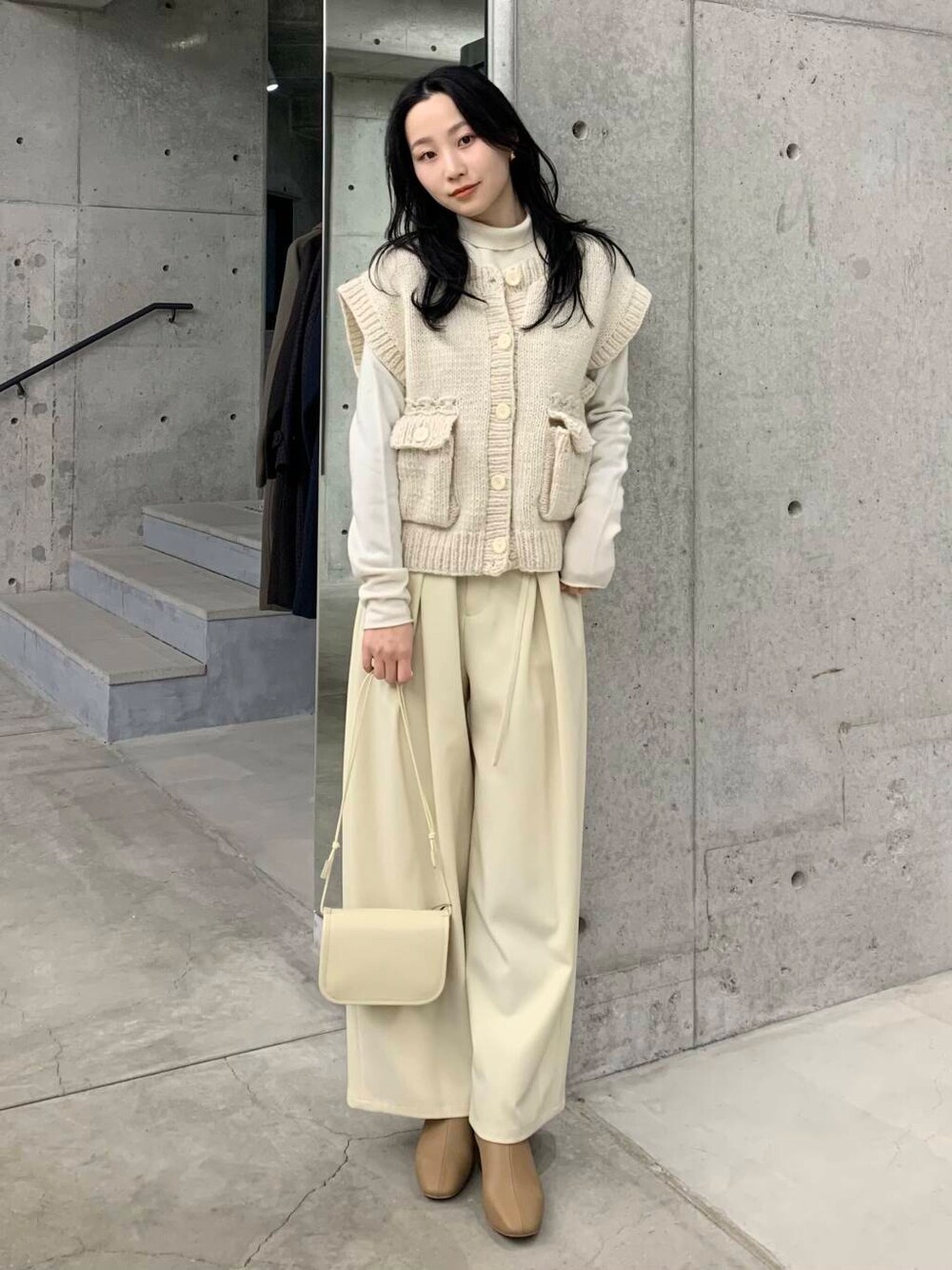 ベージュ系のブーツ、ホワイト系のその他パンツ、ホワイト系のベストを着用したレディースの冬コーディネートの3枚目の写真