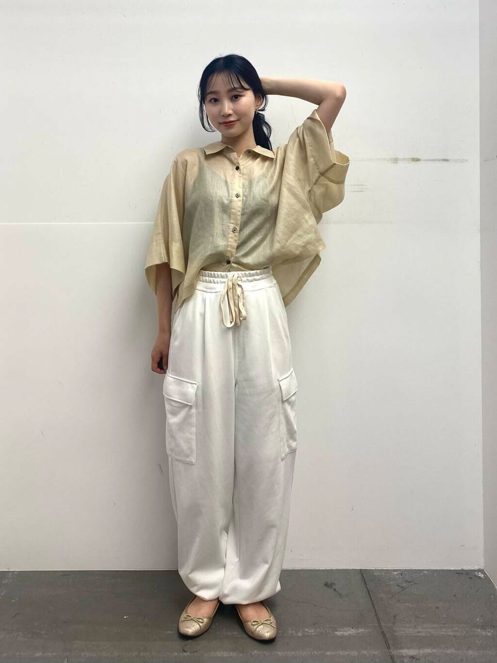 ベージュ系のショルダーバッグ、ベージュ系のシャツ/ブラウス、ホワイト系のカーゴパンツを着用したレディースの夏コーディネートの3枚目の写真