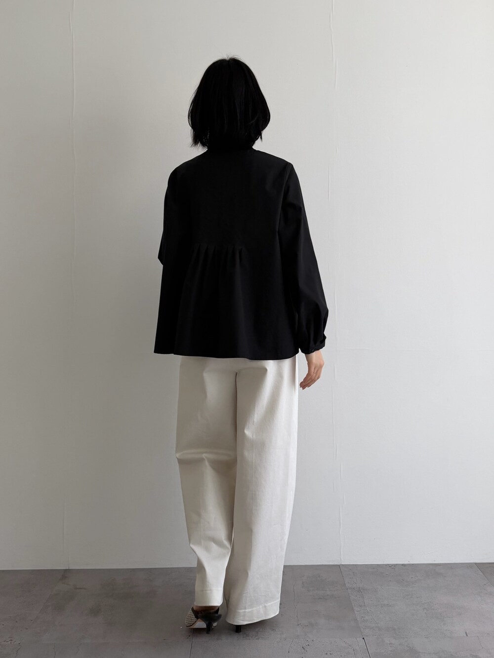 ブラック系のシャツ/ブラウス、ホワイト系のその他パンツ、ブラック系のパンプスを着用したレディースの冬コーディネートの5枚目の写真