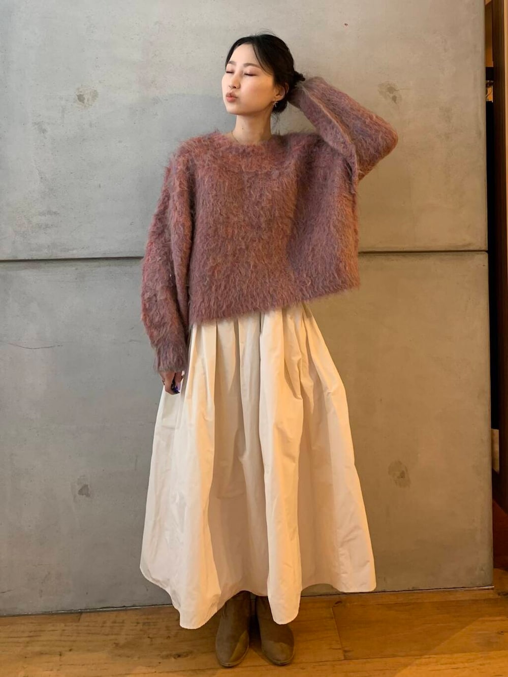 ピンク系のニット/セーター、ホワイト系のスカートを着用したレディースの秋コーディネートの4枚目の写真