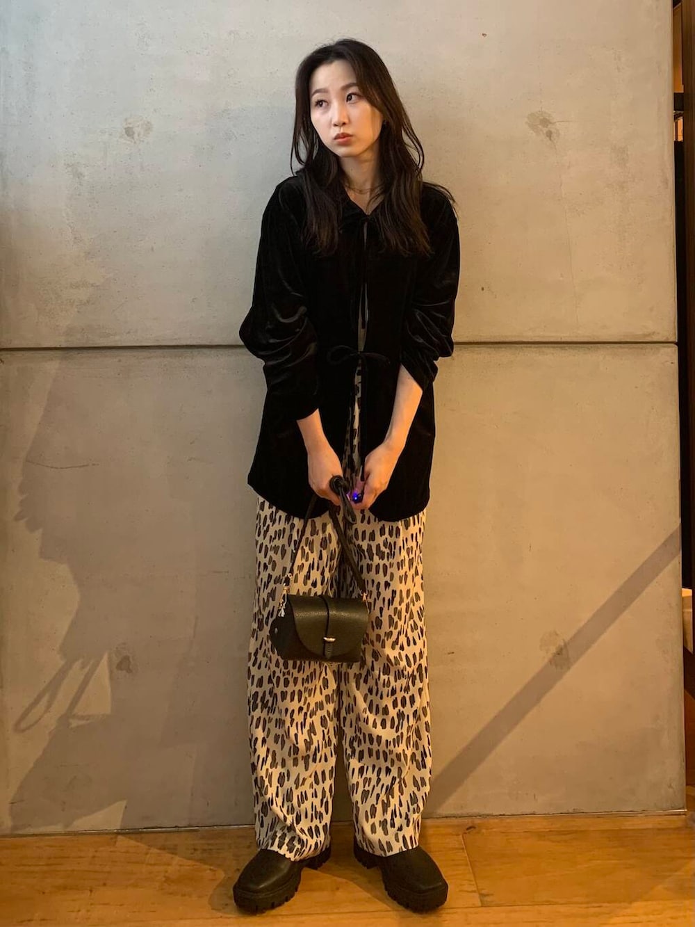 ブラック系のショルダーバッグ、ホワイト系のその他パンツ、ブラック系のブーツを着用したレディースの秋コーディネートの4枚目の写真