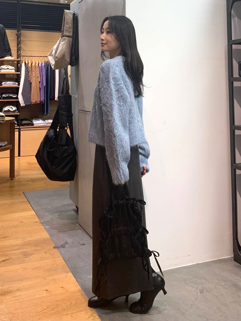 ブラック系のブーツ、グレー系のスカート、ブルー系のカーディガン/ボレロを着用したレディースの冬コーディネートの5枚目の写真