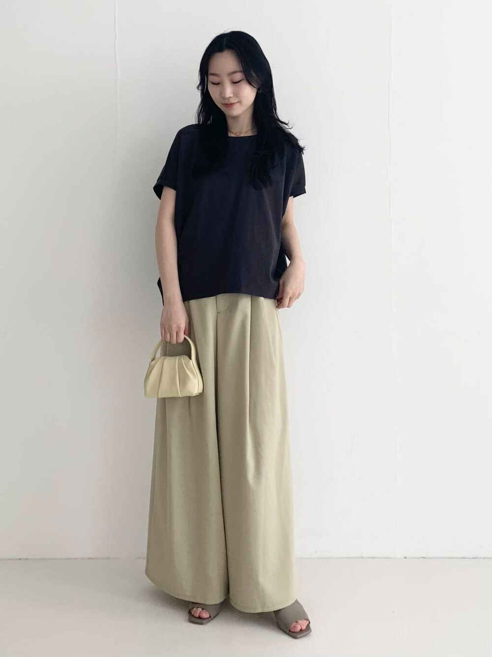 ベージュ系のその他パンツ、イエロー系のハンドバッグ、ブラウン系のTシャツ/カットソーを着用したレディースの春コーディネートの3枚目の写真