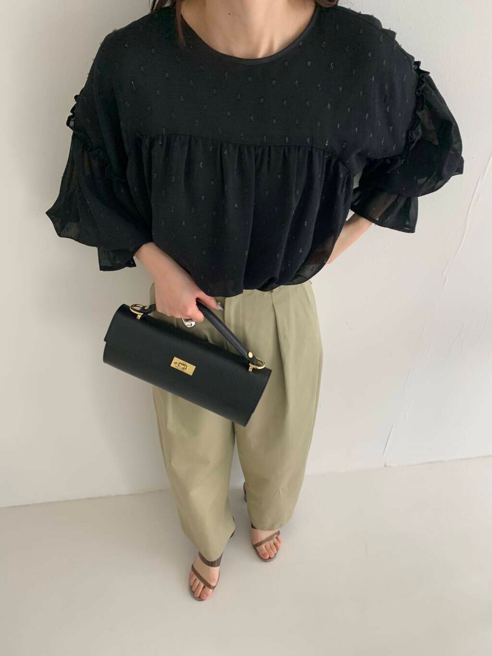 ブラック系のシャツ/ブラウス、ベージュ系のその他パンツ、ブラック系のショルダーバッグを着用したレディースの春コーディネートの3枚目の写真