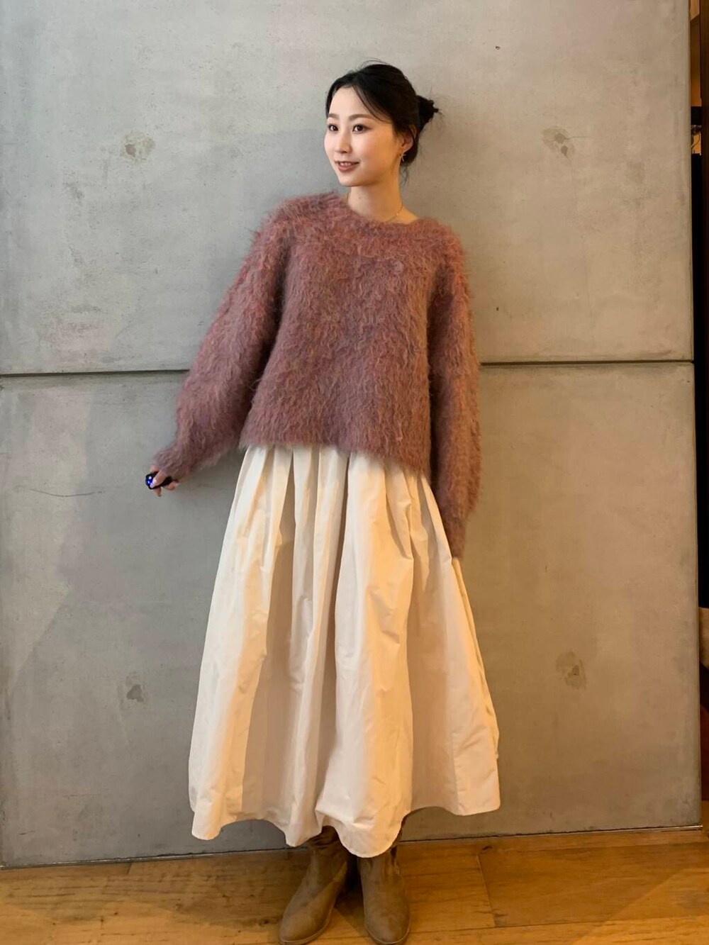 ピンク系のニット/セーター、ホワイト系のスカートを着用したレディースの秋コーディネートの2枚目の写真