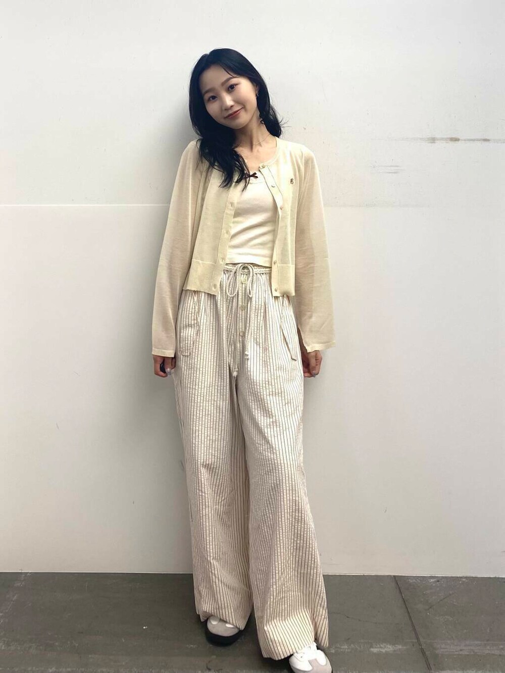 レッド系のその他パンツ、ホワイト系のカーディガン/ボレロ、ホワイト系のスニーカーを着用したレディースの夏コーディネートの4枚目の写真