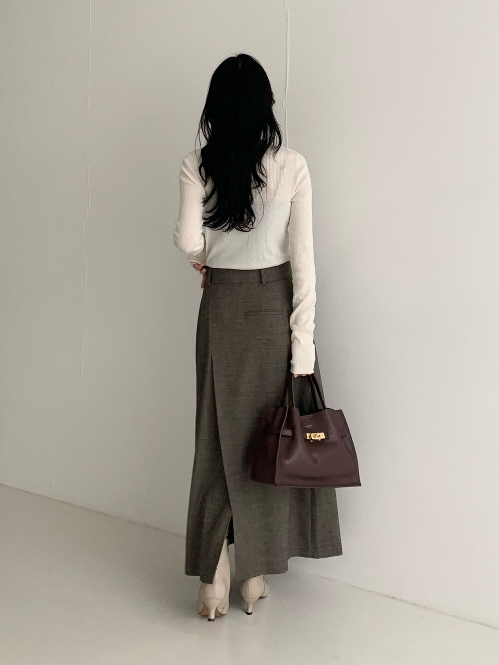 ホワイト系のニット/セーター、ブラウン系のスカートを着用したレディースの秋コーディネートの5枚目の写真