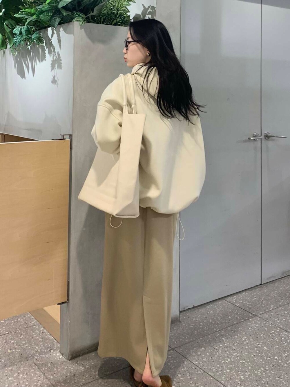 イエロー系のその他シューズ、ベージュ系のスカート、ホワイト系のパーカーを着用したレディースの冬コーディネートの6枚目の写真