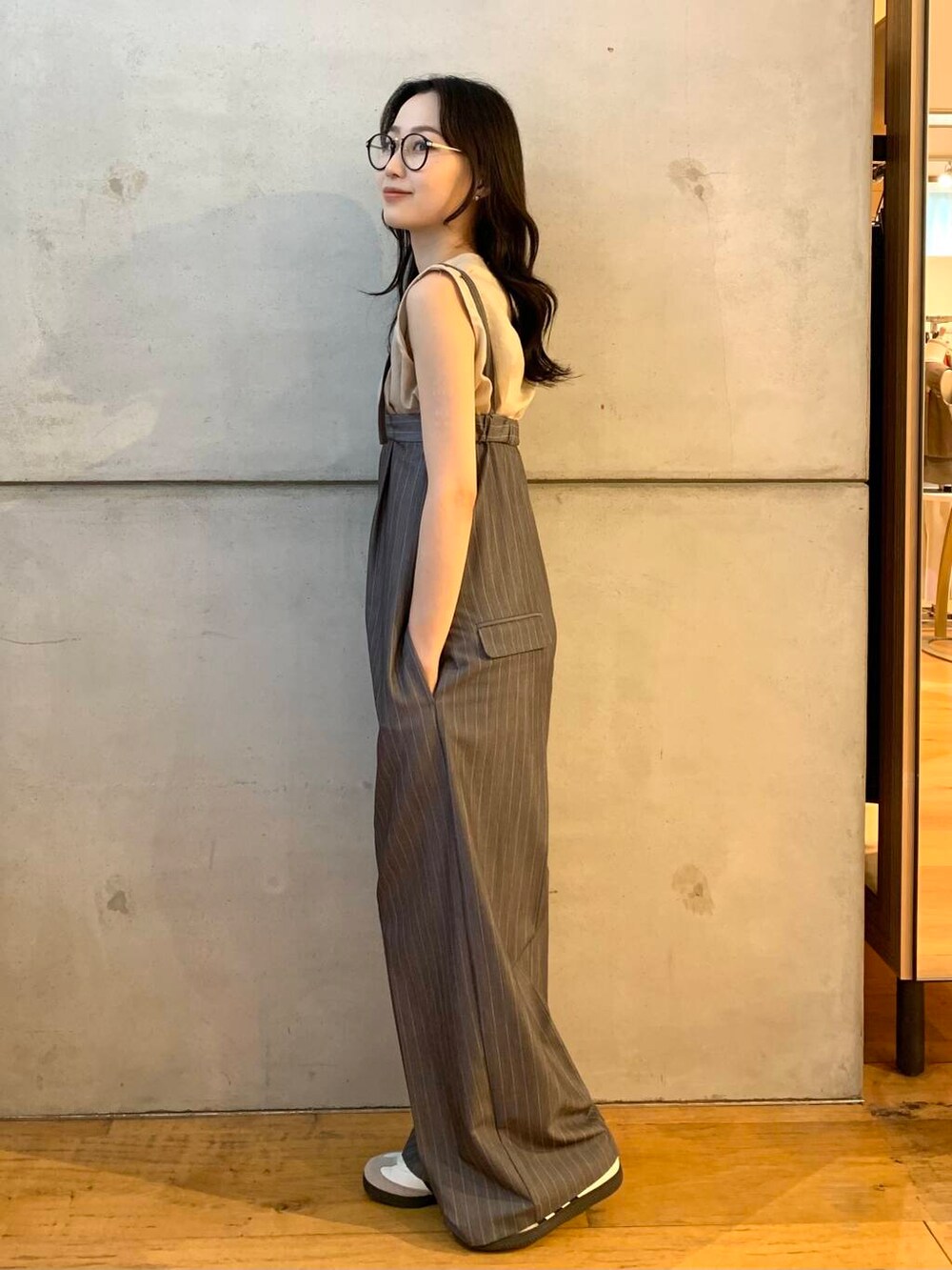 ベージュ系のシャツ/ブラウス、ホワイト系のスニーカー、グレー系のサロペット/オーバーオールを着用したレディースの夏コーディネートの5枚目の写真