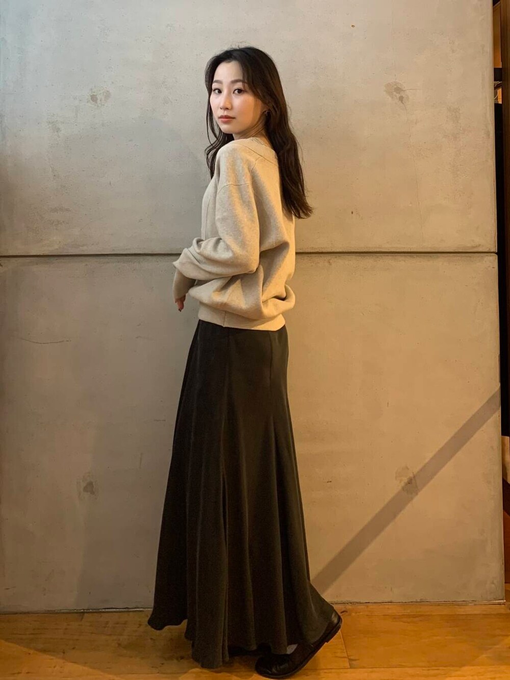 グレー系のスカート、ベージュ系のタンクトップ、ベージュ系のニット/セーターを着用したレディースの秋コーディネートの5枚目の写真