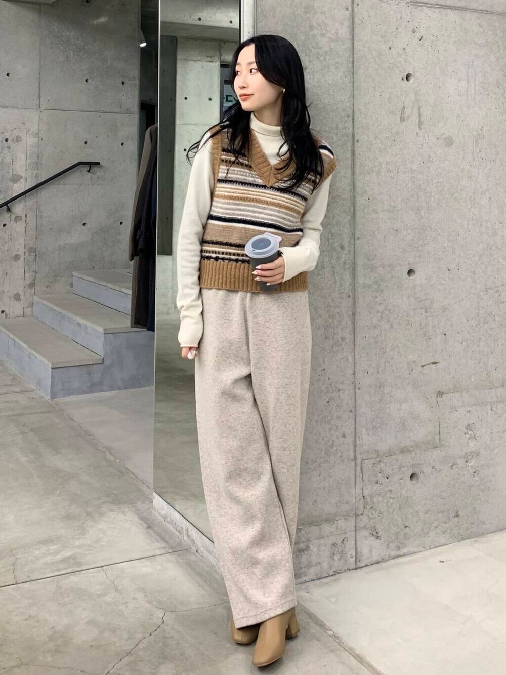 ベージュ系のブーツ、ブラウン系のベスト、ベージュ系のその他パンツを着用したレディースの冬コーディネートの3枚目の写真