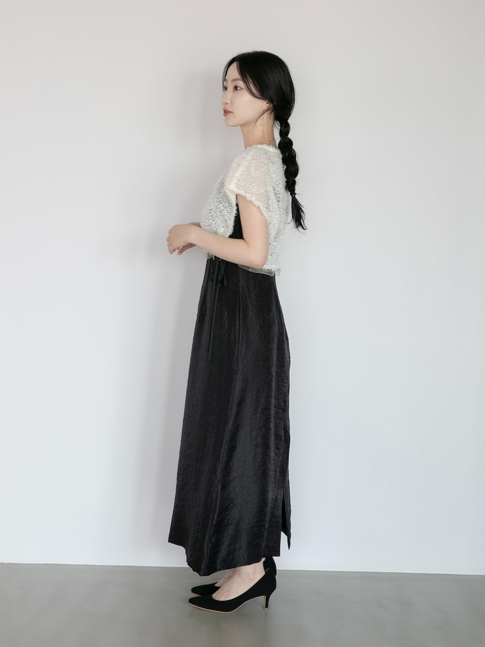 ブラック系のワンピース、ブラック系のパンプスを着用したレディースの夏コーディネートの2枚目の写真