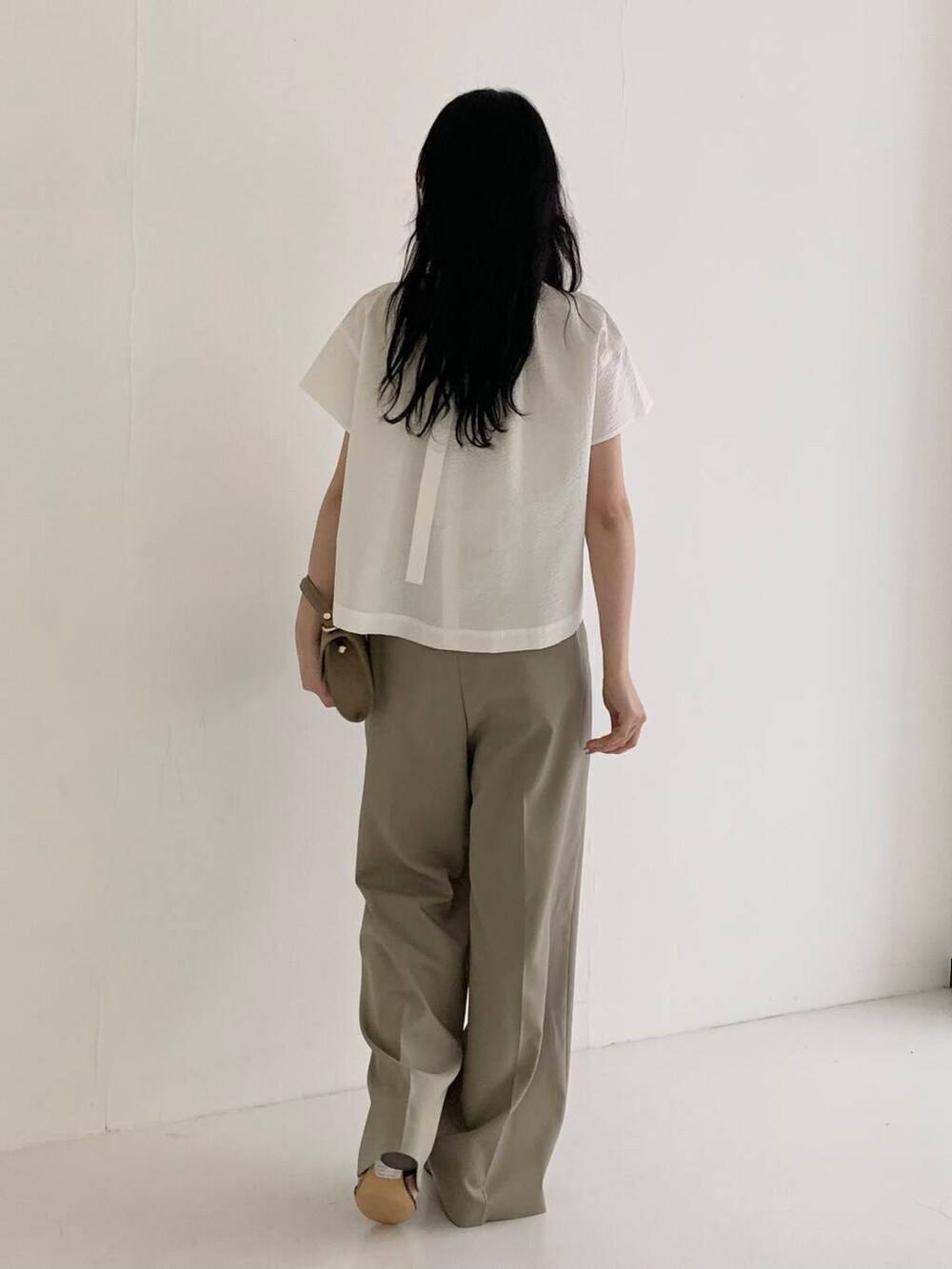 ベージュ系のショルダーバッグ、ブラウン系のその他パンツ、ホワイト系のシャツ/ブラウスを着用したレディースの春コーディネートの3枚目の写真
