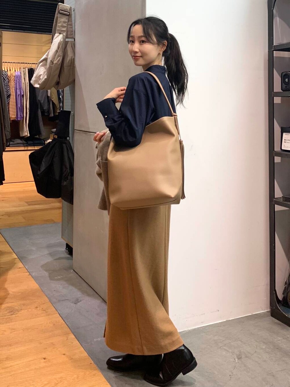 ブラック系のブーツ、ブラウン系のカーディガン/ボレロ、ベージュ系のトートバッグを着用したレディースの秋コーディネートの6枚目の写真