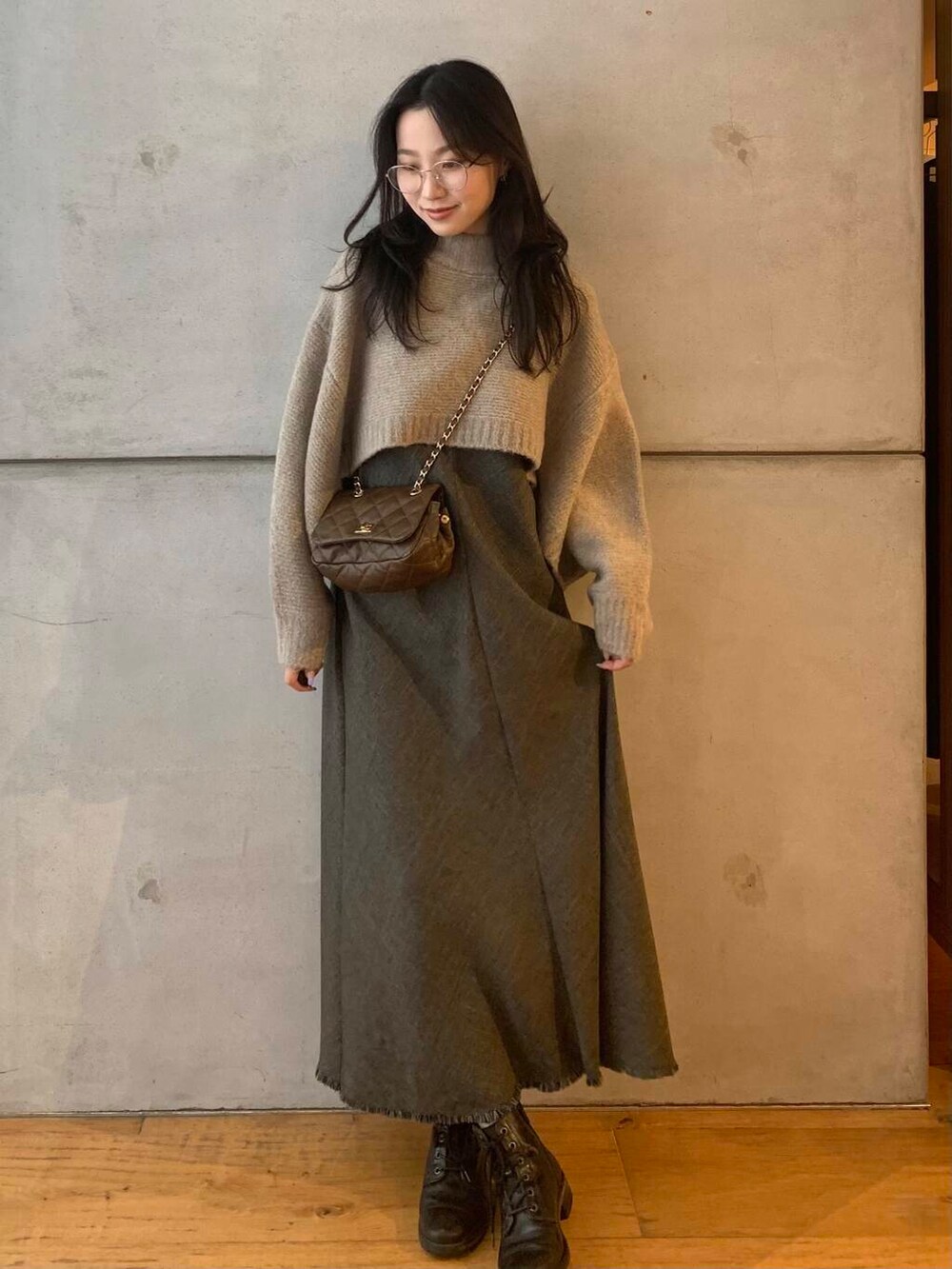 ブラウン系のショルダーバッグ、ブラウン系のワンピース、ベージュ系のニット/セーターを着用したレディースの秋コーディネートの2枚目の写真