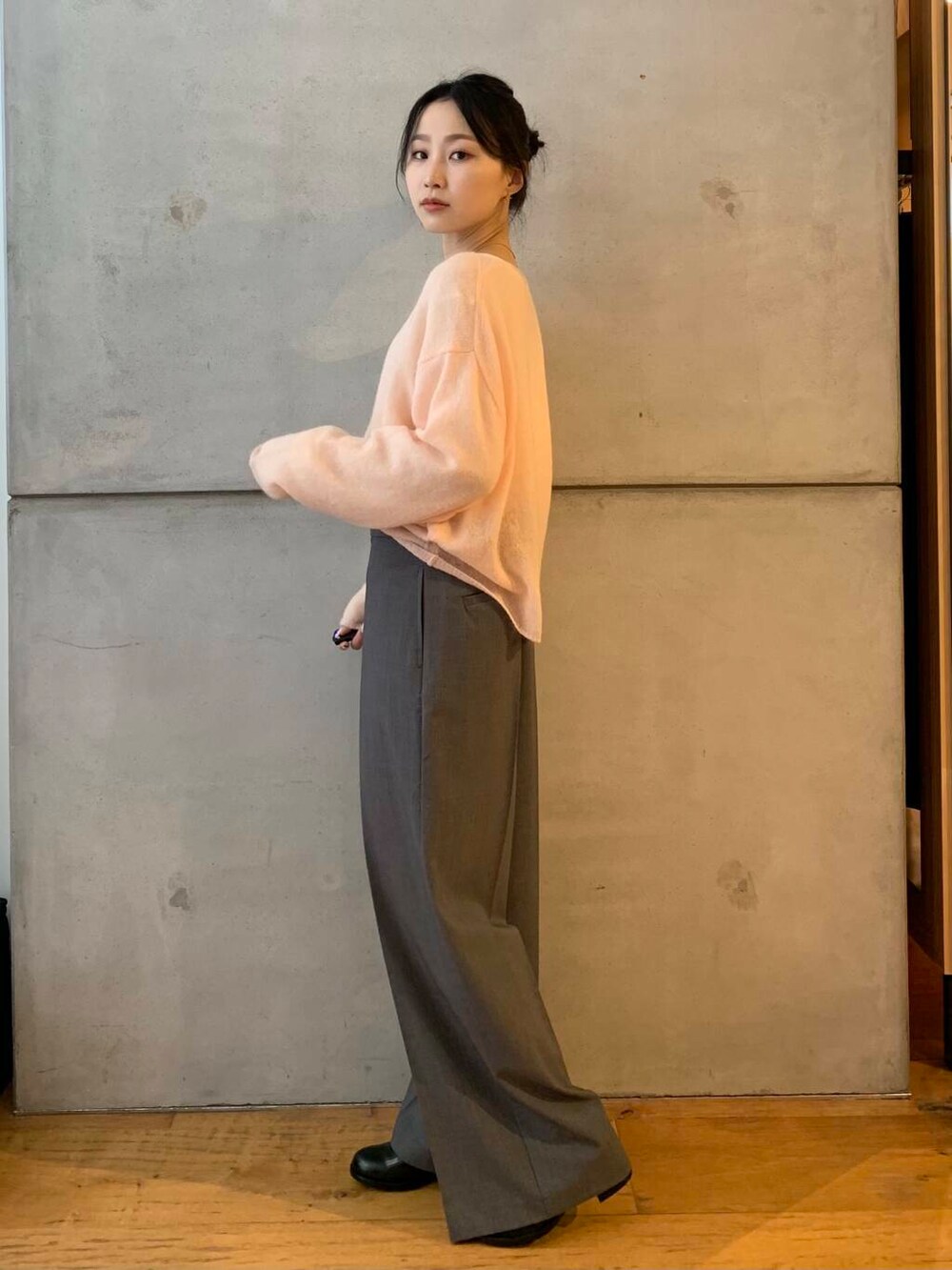 グレー系のその他パンツ、ブラック系のレインシューズ、ピンク系のニット/セーターを着用したレディースの秋コーディネートの4枚目の写真