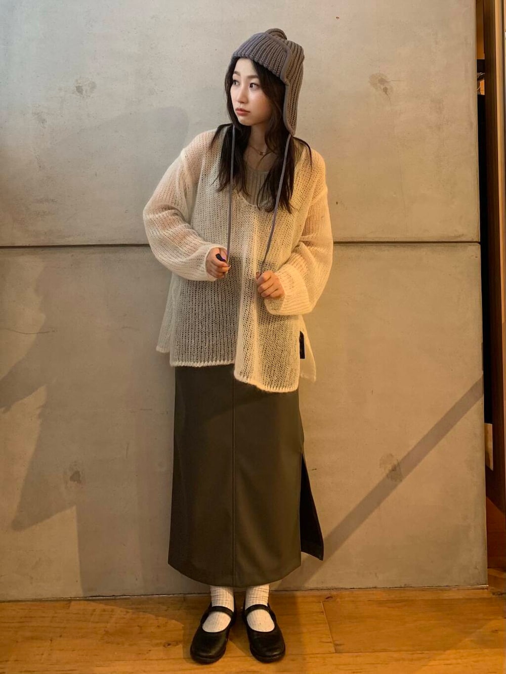 ベージュ系のタンクトップ、グレー系のスカート、ホワイト系のニット/セーターを着用したレディースの秋コーディネートの2枚目の写真