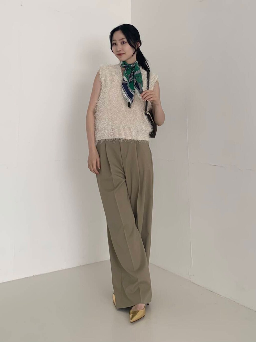 ベージュ系のその他パンツ、ホワイト系のベスト、ブラウン系のショルダーバッグを着用したレディースの夏コーディネートの2枚目の写真