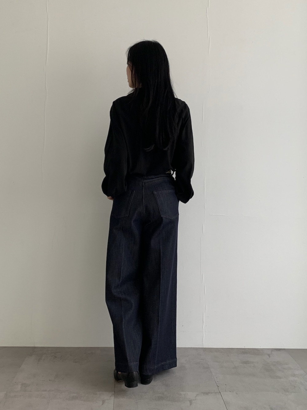 ブルー系のデニムパンツ、ブラック系のシャツ/ブラウスを着用したレディースの春コーディネートの3枚目の写真