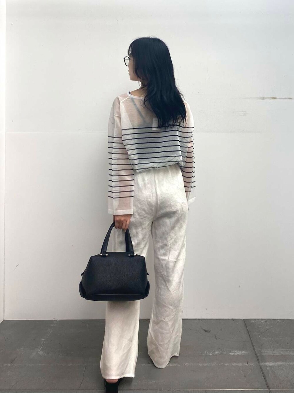 ブラック系のサンダル、ブラック系のハンドバッグ、ホワイト系のその他パンツを着用したレディースの夏コーディネートの6枚目の写真