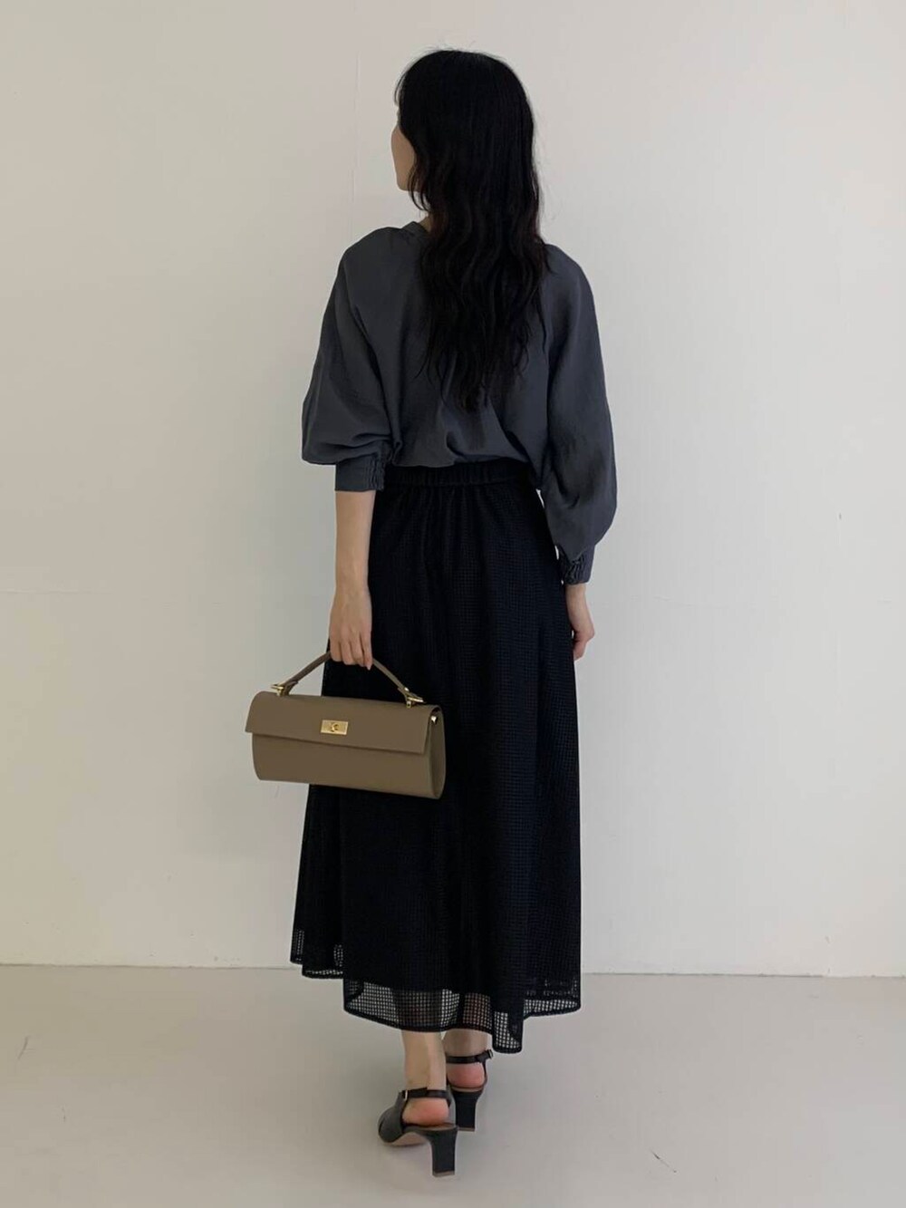 グレー系のシャツ/ブラウス、ブラック系のスカート、ベージュ系のショルダーバッグを着用したレディースの春コーディネートの4枚目の写真