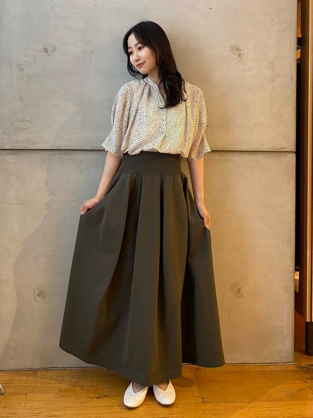 ホワイト系のパンプス、グリーン系のスカート、ホワイト系のシャツ/ブラウスを着用したレディースの夏コーディネートの3枚目の写真