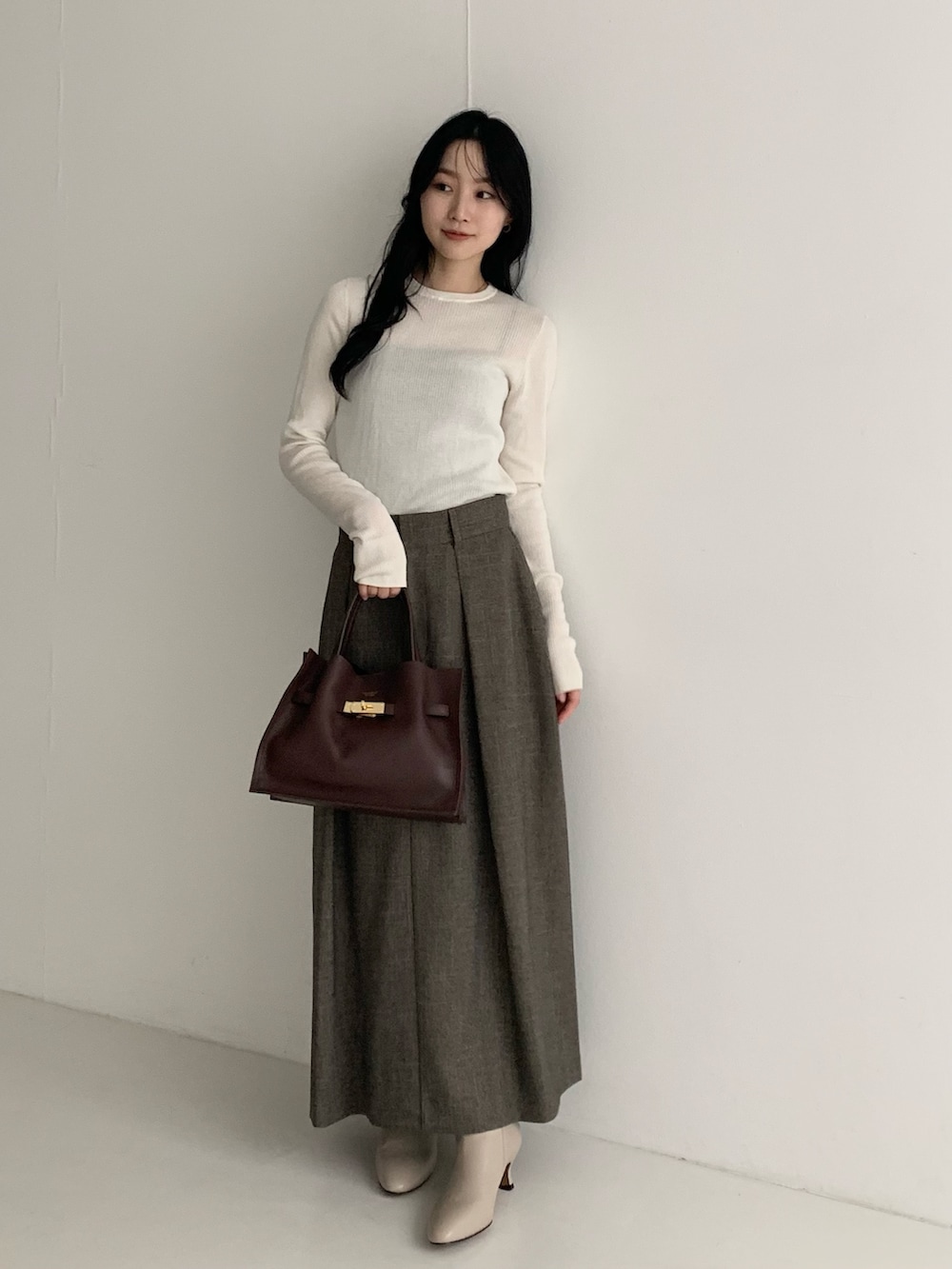 ホワイト系のニット/セーター、ブラウン系のスカートを着用したレディースの秋コーディネートの3枚目の写真