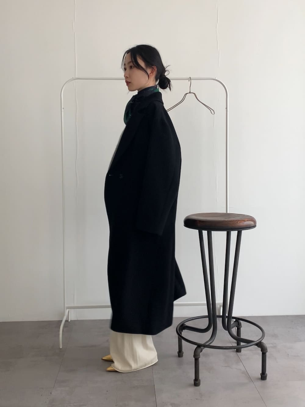 グレー系のニット/セーター、ホワイト系のその他パンツ、ブラック系のチェスターコートを着用したレディースの冬コーディネートの4枚目の写真