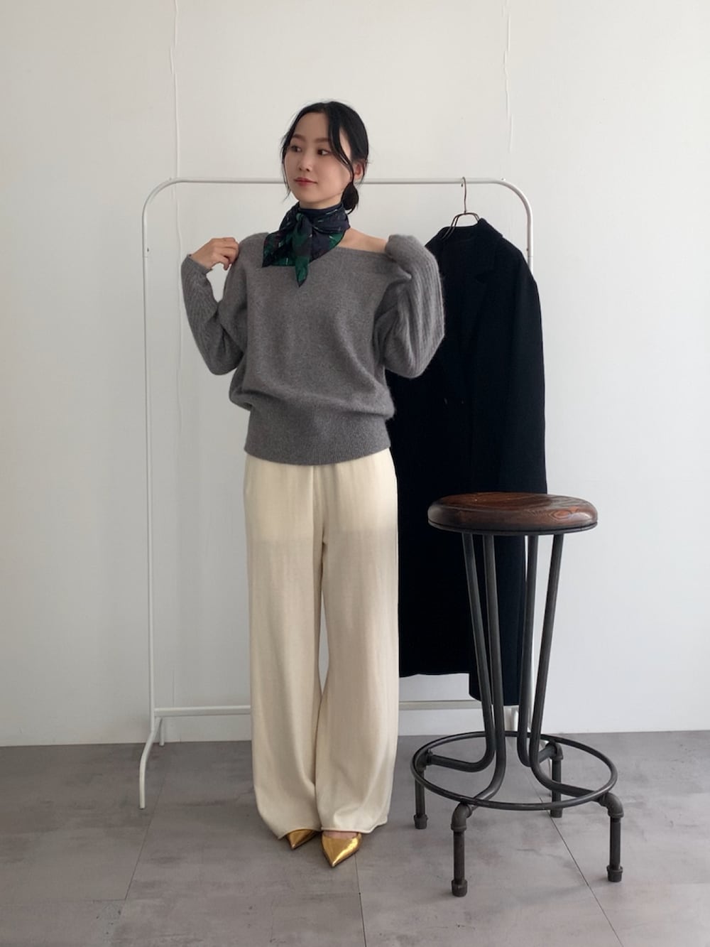 グレー系のニット/セーター、ホワイト系のその他パンツ、ブラック系のチェスターコートを着用したレディースの冬コーディネートの3枚目の写真