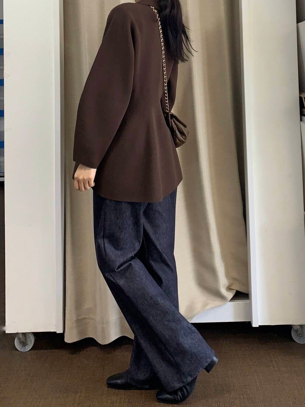 ブラウン系のショルダーバッグ、ブルー系のデニムパンツ、ブラウン系のニット/セーターを着用したレディースの秋コーディネートの3枚目の写真