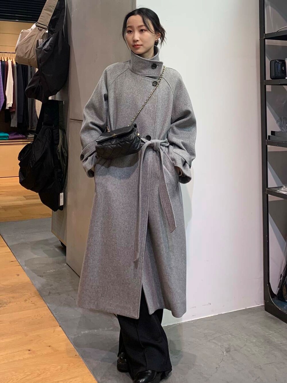 ブラック系のブーツ、ブラック系のショルダーバッグ、グレー系のその他アウターを着用したレディースの冬コーディネートの3枚目の写真