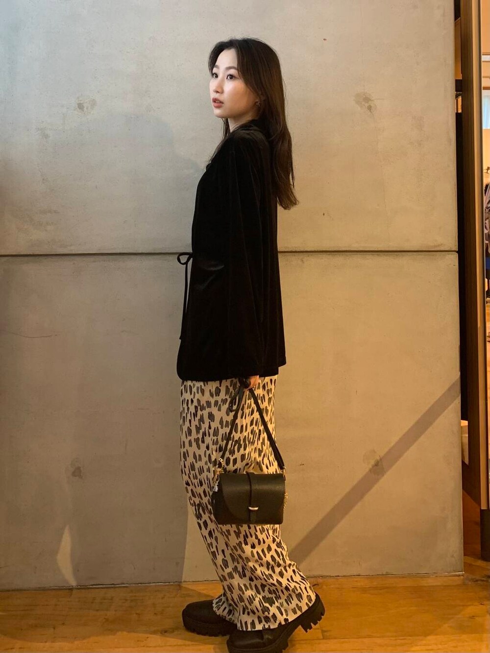 ブラック系のショルダーバッグ、ホワイト系のその他パンツ、ブラック系のブーツを着用したレディースの秋コーディネートの6枚目の写真