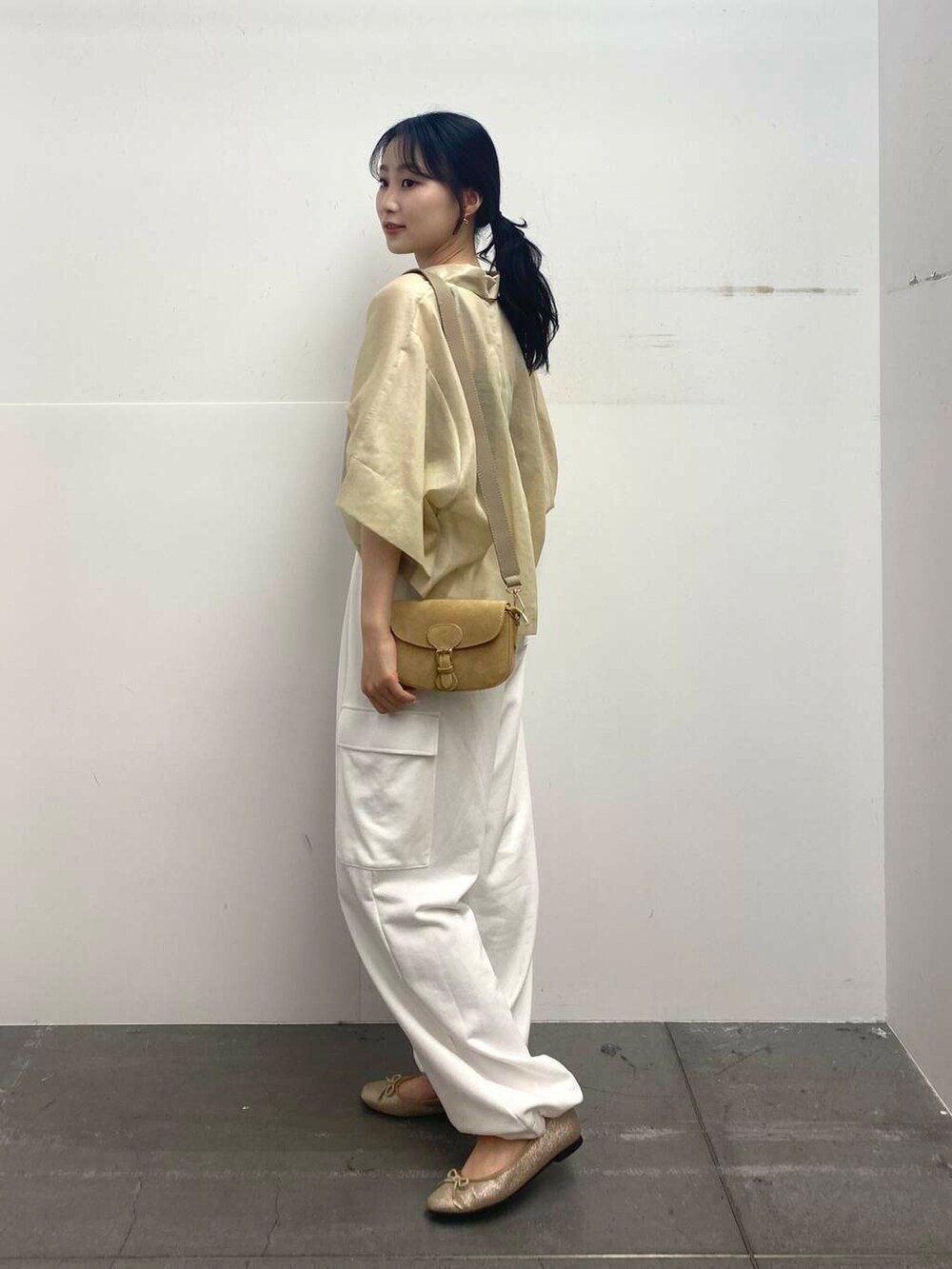 ベージュ系のショルダーバッグ、ベージュ系のシャツ/ブラウス、ホワイト系のカーゴパンツを着用したレディースの夏コーディネートの5枚目の写真