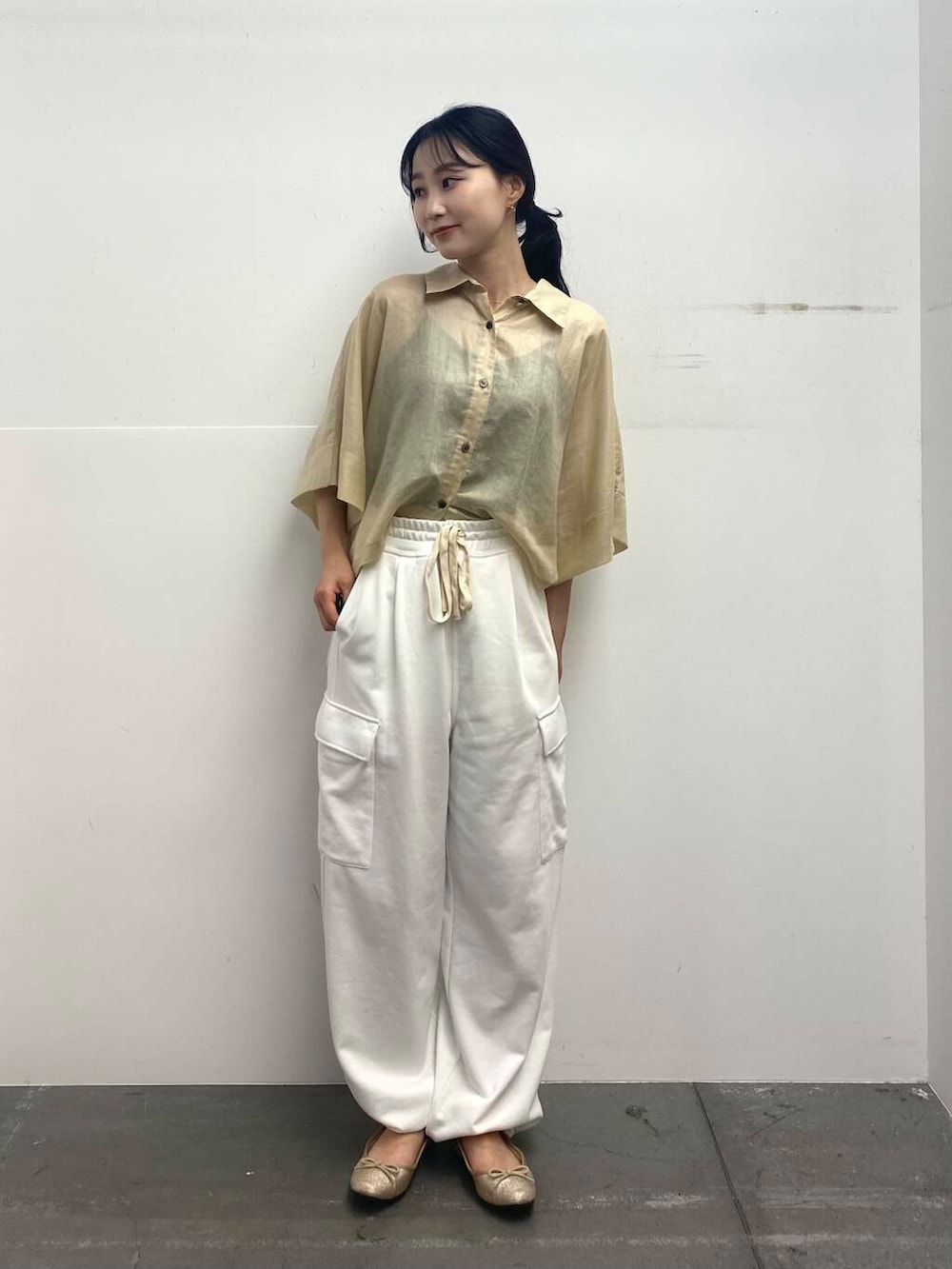 ベージュ系のショルダーバッグ、ベージュ系のシャツ/ブラウス、ホワイト系のカーゴパンツを着用したレディースの夏コーディネートの2枚目の写真