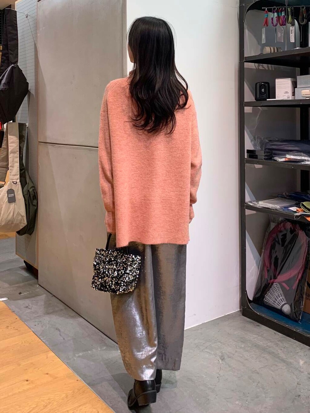 シルバー系のショルダーバッグ、ブラック系のブーツ、シルバー系のスカートを着用したレディースの冬コーディネートの7枚目の写真