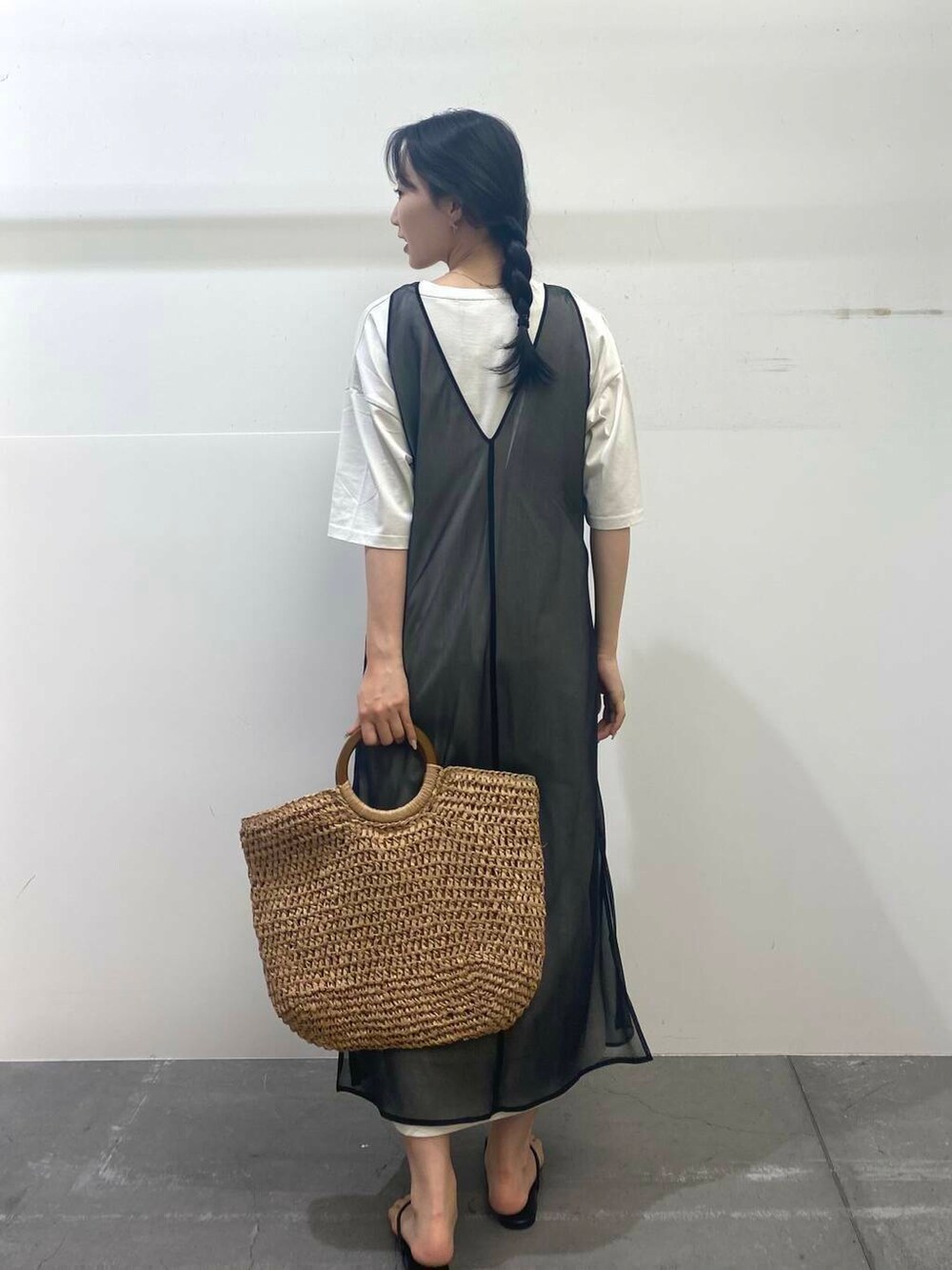 ベージュ系のトートバッグ、ブラック系のサンダル、ブラック系のワンピースを着用したレディースの夏コーディネートの6枚目の写真