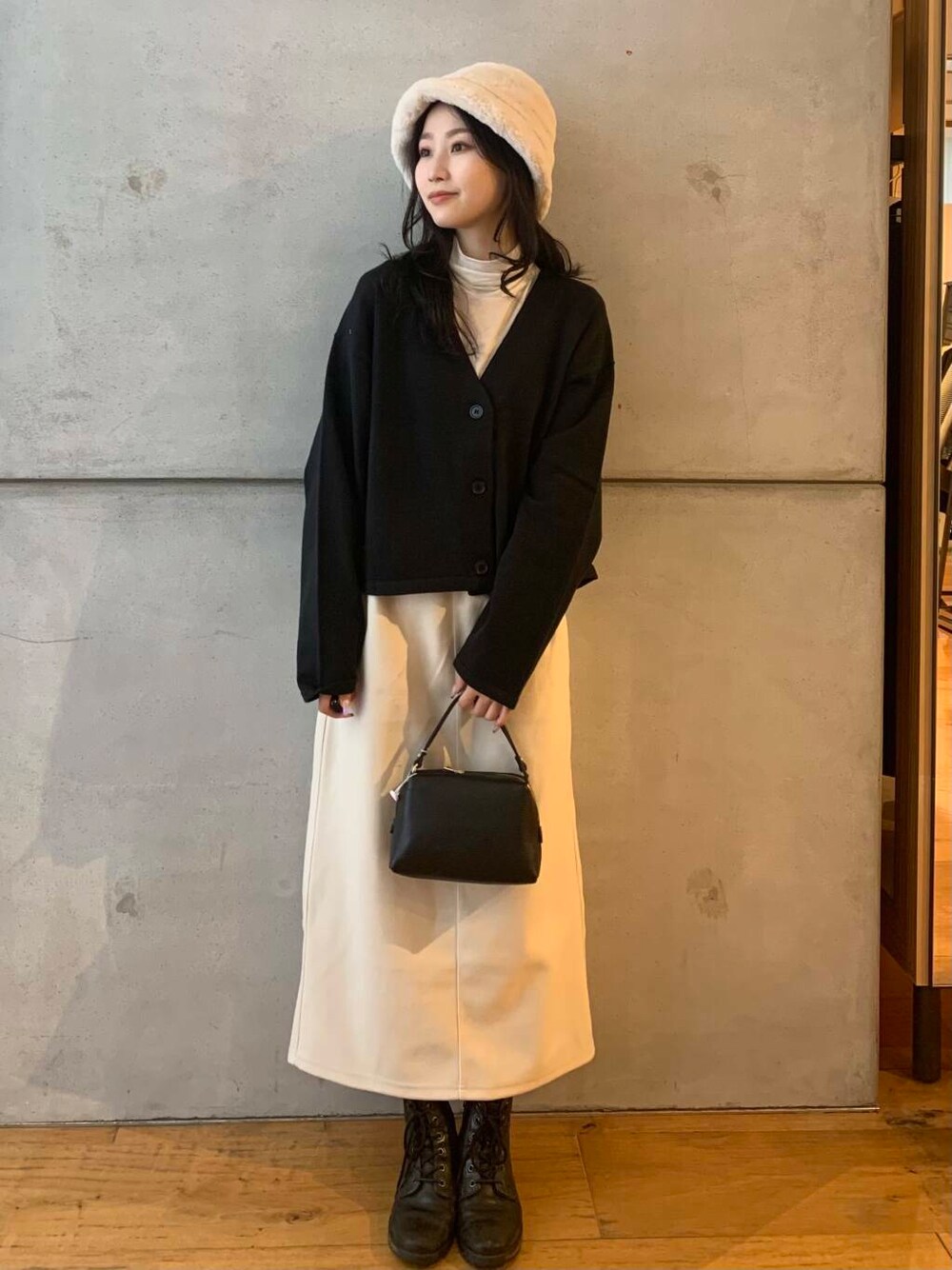 ホワイト系のTシャツ/カットソー、ブラック系のカーディガン/ボレロ、ホワイト系のスカートを着用したレディースの秋コーディネートの3枚目の写真