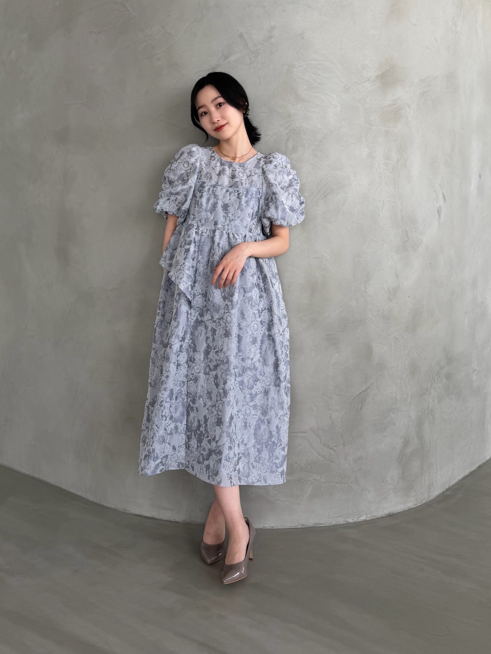 グレー系のワンピースを着用したレディースの冬コーディネートの2枚目の写真