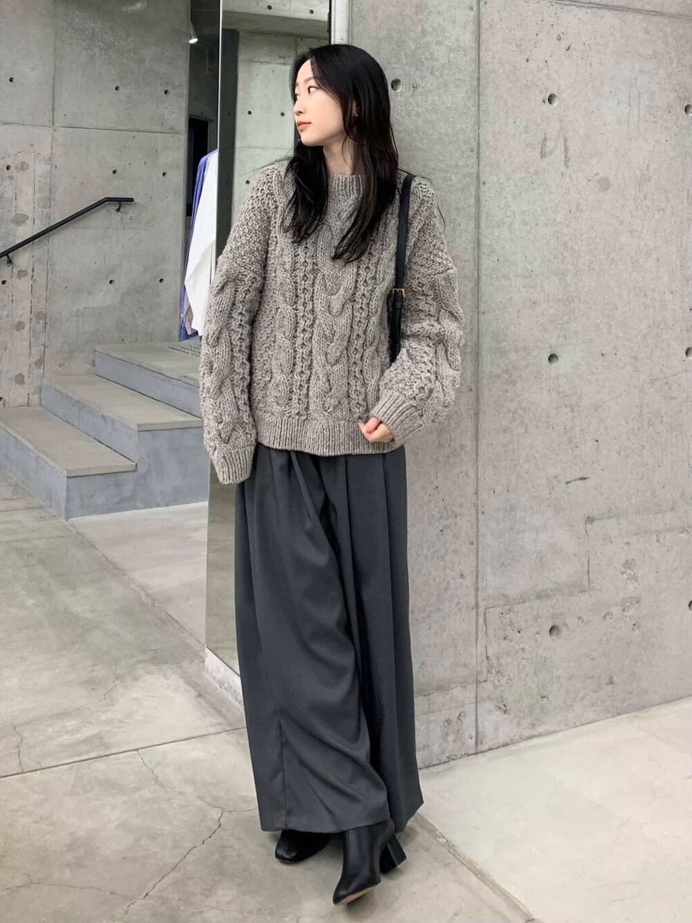 グレー系のニット/セーター、ブラック系のブーツ、グレー系のその他パンツを着用したレディースの冬コーディネートの2枚目の写真