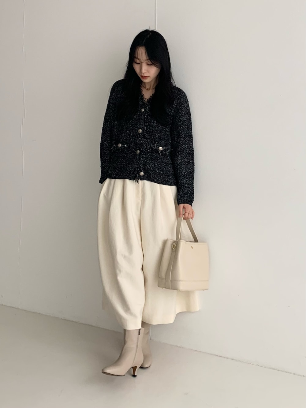 ブラック系のカーディガン/ボレロ、ホワイト系のその他パンツ、ホワイト系のハンドバッグを着用したレディースの秋コーディネートの2枚目の写真